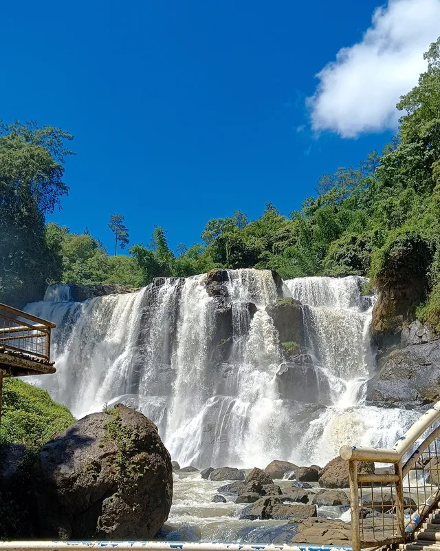 Air terjun dan pagar area pandang Curug Malela pada Februari 2024. / Waterfall and viewing-area railing at Curug Malela in February 2024.