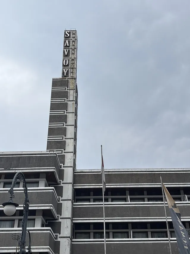 Detail menara bertuliskan Savoy Homann dan garis fasad, Mei 2025. / Savoy Homann name tower and facade lines, May 2025.