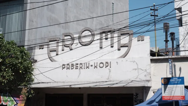 Detail tulisan Aroma pada fasad pabrik kopi. / Aroma lettering on the coffee factory facade.