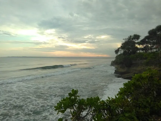 Pemandangan senja di Pantai Batu Hiu dengan laut dan tebing pantai