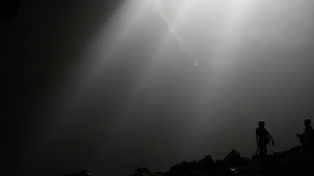 Berkas cahaya dan siluet pengunjung pada jalur gua Jomblang–Grubug, foto arsip 2014 / Light rays and visitor silhouettes on the Jomblang–Grubug cave route, archive photo from 2014