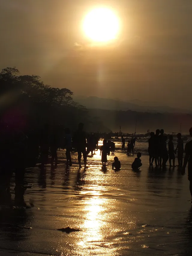 Siluet pengunjung di tepi Pantai Santolo pada pagi hari.