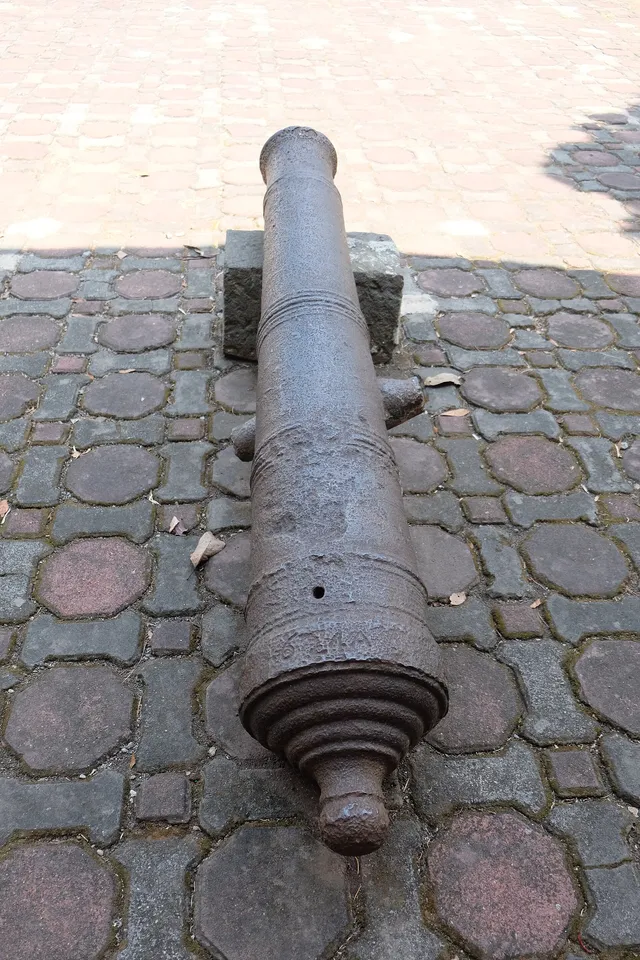 ID: Meriam koleksi Museum Prabu Geusan Ulun di atas penyangga batu. EN: A cannon in Museum Prabu Geusan Ulun’s collection resting on stone supports.