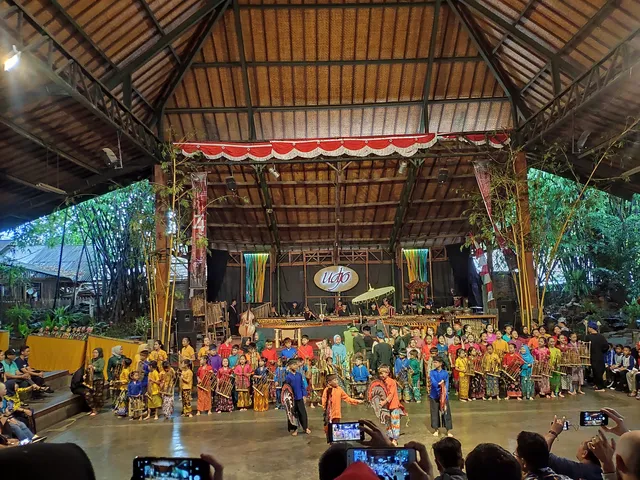 ID: Panggung terbuka beratap besar di Saung Angklung Udjo. EN: Roofed open-air stage at Saung Angklung Udjo.