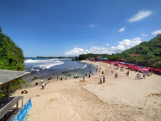 Pantai Pulangsawal dari sisi timur dengan pasir, ombak dan payung merah, Mei 2025 / Pulangsawal beach from the east with sand, waves and red umbrellas, May 2025