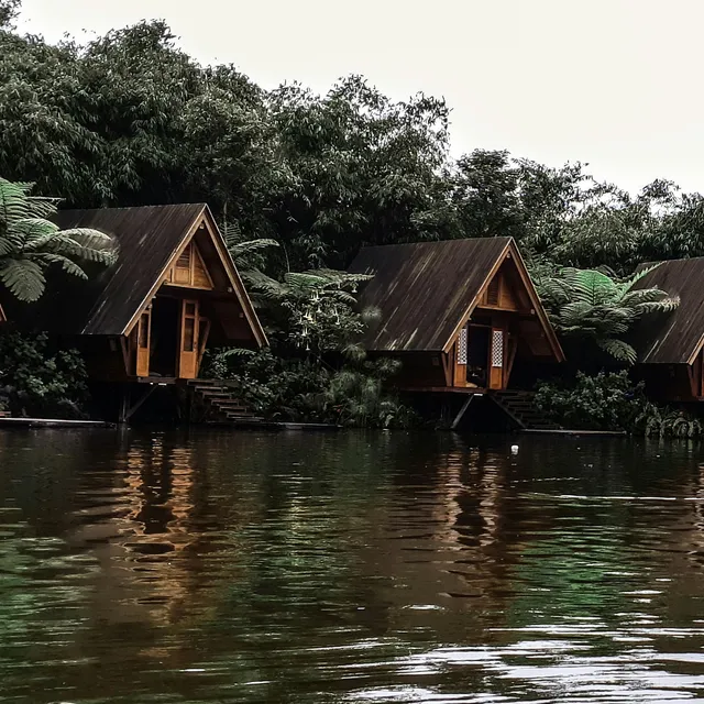 ID: Saung kayu dan pantulannya di danau Dusun Bambu. EN: Wooden pavilions and their reflections in Dusun Bambu lake.