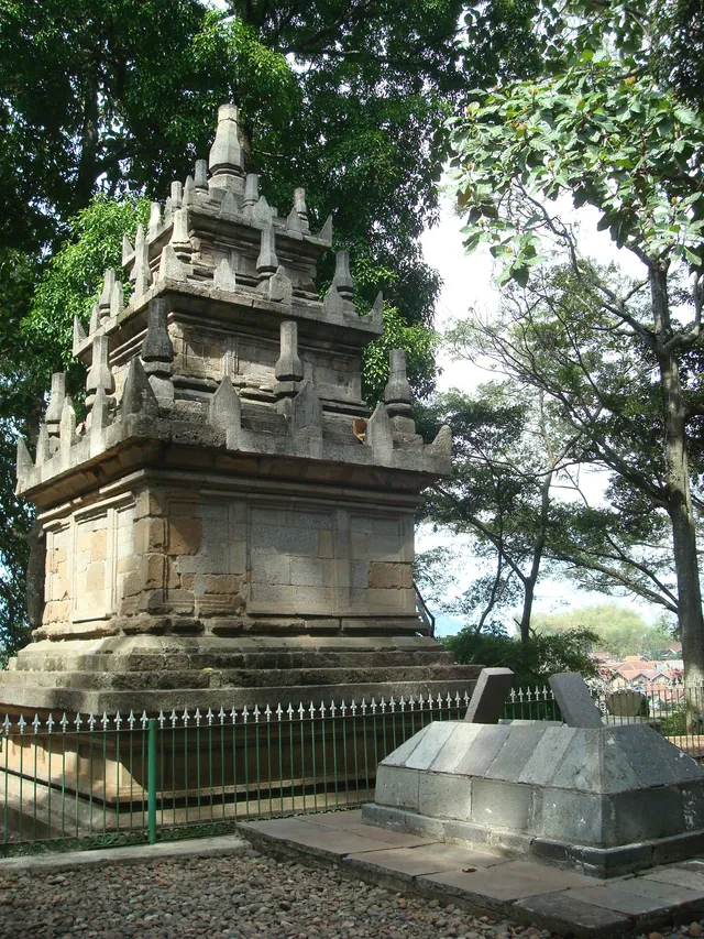 ID: Sisi Candi Cangkuang di bawah pepohonan. EN: A side view of Cangkuang Temple beneath trees.
