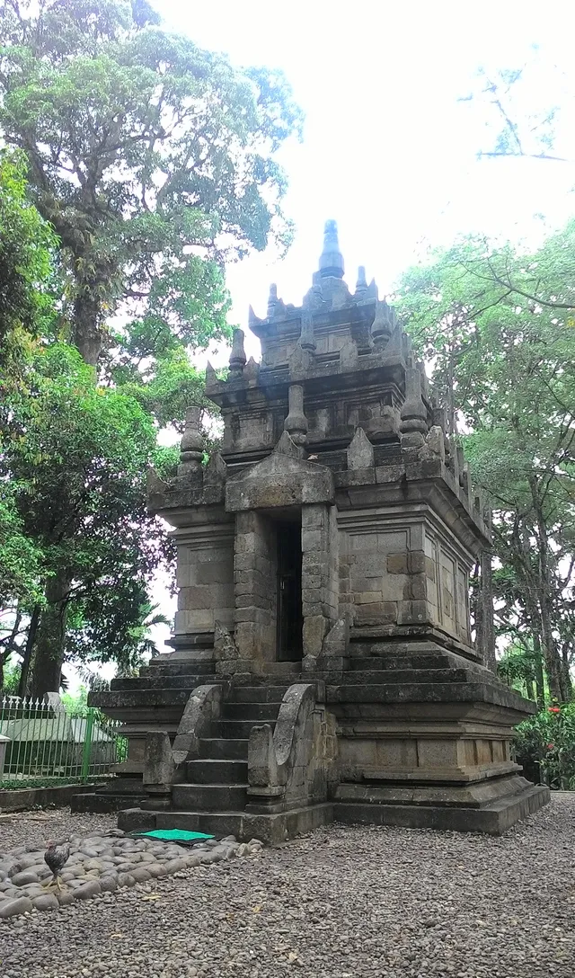 ID: Bangunan batu dan tangga Candi Cangkuang dilihat dari sudut depan. EN: The stone structure and steps of Cangkuang Temple from a front angle.