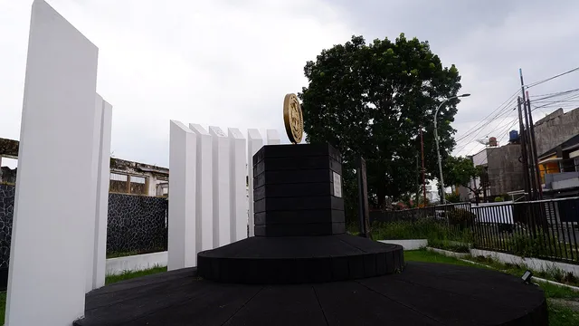 Tugu Koperasi Indonesia dari sisi kanan dengan pepohonan di latar, Februari 2026. / Right-side view of the Indonesian Cooperative Monument with trees behind it, February 2026.