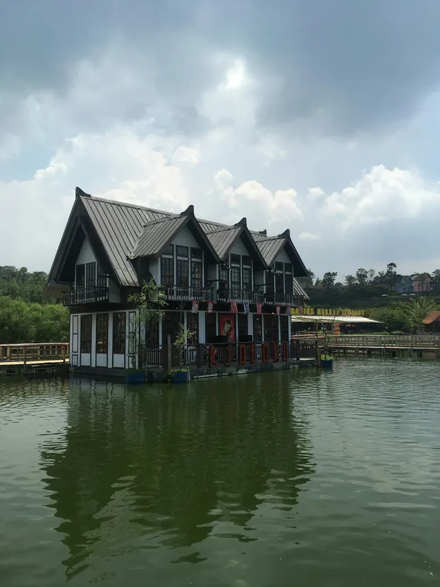 ID: Bangunan beratap pelana di tepi danau Floating Market Lembang, Kabupaten Bandung Barat. EN: A gabled lakeside building at Floating Market Lembang, West Bandung Regency.