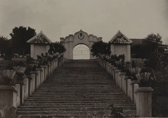 Foto arsip tangga dan gerbang Girigondo dengan lambang PA V; tanggal pengambilan tidak diketahui / Archive photograph of Girigondo steps and gateway with PA V emblem; capture date unknown