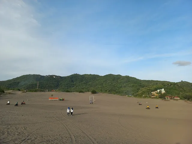 Hamparan pasir Gumuk Pasir Parangkusumo dengan perbukitan di belakang, foto arsip2022 / Parangkusumo sand dunes with hills behind, archive photograph from2022