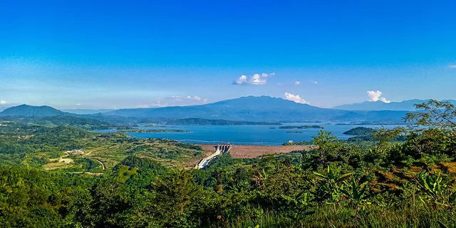 Bendungan dan bentang Waduk Jatigede dari Puncak Pareugreug dalam foto April 2021. / Dam and reservoir landscape from Puncak Pareugreug in an April 2021 photograph.
